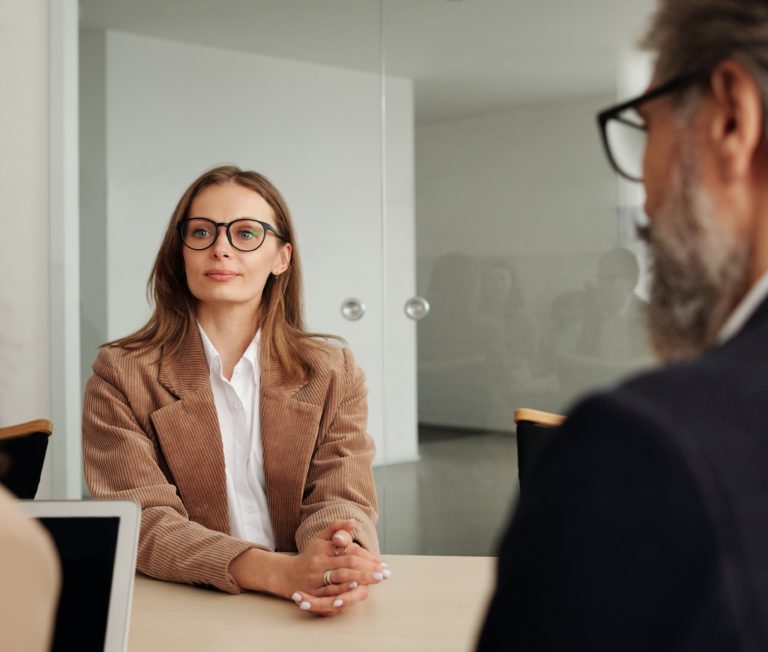 Woman Sitting in a Meeting Facing a Man